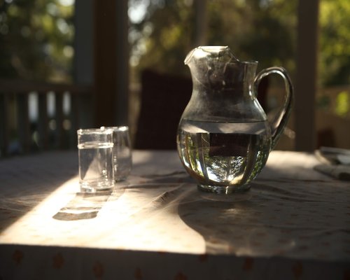 Person pouring a glass of water from a pitcher