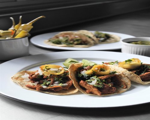 A plate of traditional Mexican food with beans, nopal, and fresh tortillas